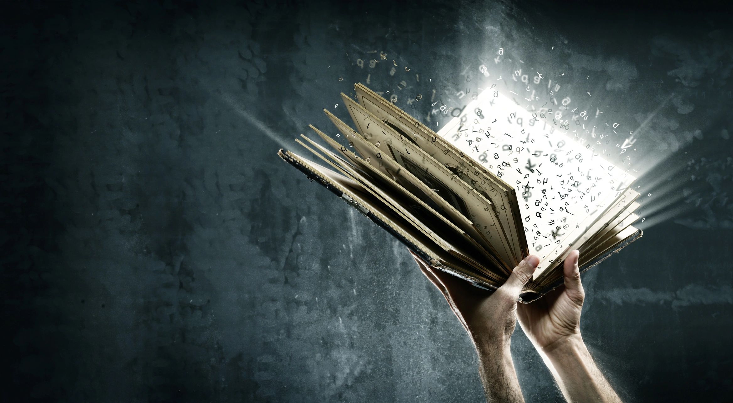 Hands holding an open magical book with glowing letters